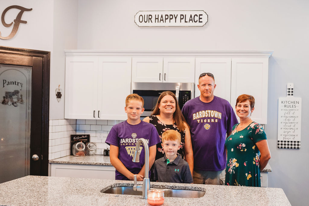 family standing in a white kitchen with a a mortgage lender